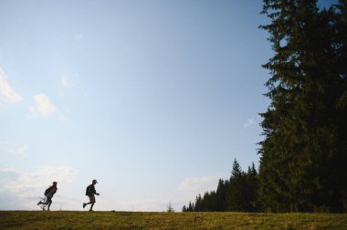 Orman kenarındaki bir çayırda koşan iki genç yürüyüşçü yaz tatilinin tadını çıkarıyor ve doğayı keşfediyor.
