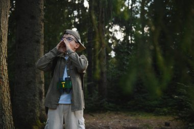 Kayıp çocuk ormanda bağırıyor. Kaşif kıyafeti giyip, dürbünle boynuna dürbün sarıp yardım istiyor.