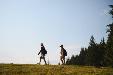 İki genç izci yemyeşil bir ormanda yaz yürüyüşünün tadını çıkarıyorlar. Doğanın güzelliğini kucaklıyorlar.