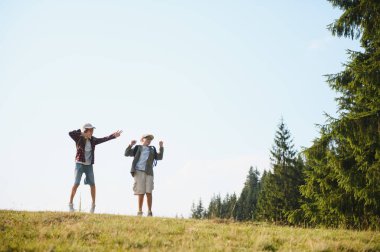 Yaz tatilleri sırasında ormanın yakınındaki bir çayıra atlayan iki neşeli izci temiz havanın ve doğanın tadını çıkarıyorlar.