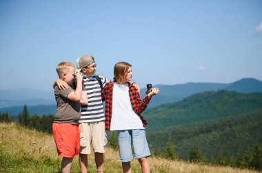 Dürbün ve aksiyon kamerasıyla doğayı keşfeden bir grup çocuk dağ tatilini kucaklıyor ve eğleniyor.