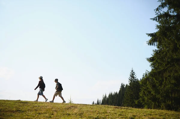 İki genç izci, yaz maceraları boyunca doğanın huzurunu kucaklayarak güzel bir ormanda yürüyüş yapıyorlar.