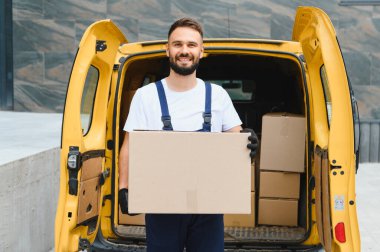 Bir teslimat minibüsünden paket getiren kurye, bir şehir ortamında müşteri kapısına paket getiren kurye.