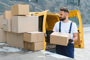 Karton kutu taşıyan kurye, teslimat minibüsünden, nakliye ve taşımacılık için paketleri düzenler