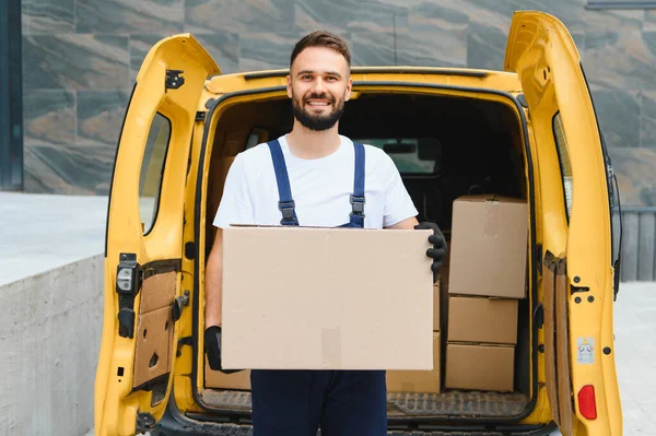 Bir teslimat minibüsünden paket getiren kurye, bir şehir ortamında müşteri kapısına paket getiren kurye.