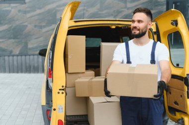 Karton kutular, nakliye ve lojistik servis konseptiyle dolu açık teslimat minibüsünden paket taşıyan kurye.