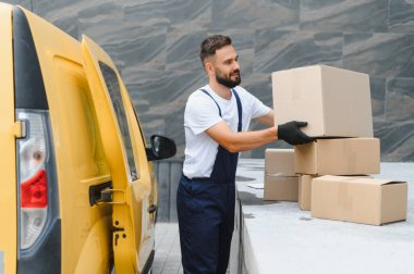 Eldiven takan kurye teslimat için paketleri düzenliyor, lojistik ve nakliyeyi verimli bir şekilde yönetiyor.