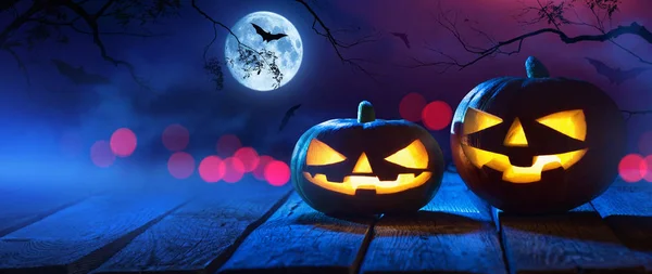 Halloween-Kürbisse auf Holz in einem gruseligen Wald bei Nacht — Stockfoto