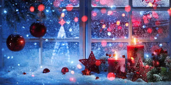 Decoración de invierno con velas cerca de la ventana cubierta de nieve — Foto de Stock