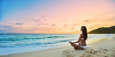 Woman Practicing Lotus Pose on Beach  clipart
