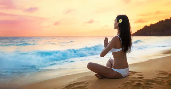 Mujer practicando Lotus Pose en la playa — Foto de Stock