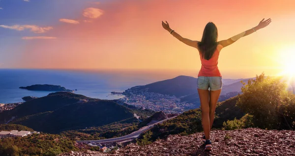 Mujer feliz en las montañas mirando el atardecer — Foto de Stock