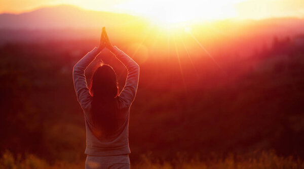 Женщина-йога медитирует на закате
