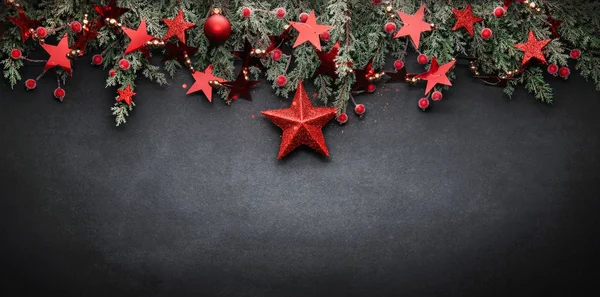 Χριστουγεννιάτικη διακόσμηση με κλαδιά ελάτων και κόκκινα αστέρια — Φωτογραφία Αρχείου