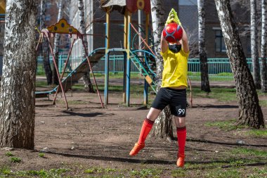 Genç futbolcu, Coronavirus salgını sırasında evin bahçesinde topla antrenman yapıyor.
