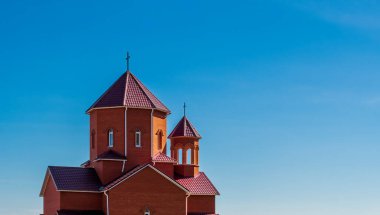 Bulutsuz mavi bir gökyüzüne karşı kulelerde haçları olan Katolik kilisesi.