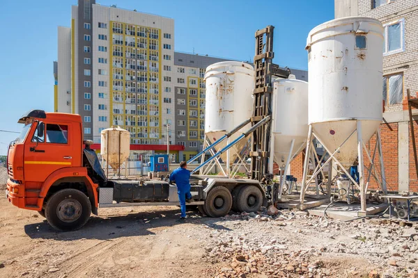 Delivery and installation of a concrete mixer on a construction site. Tank installation.