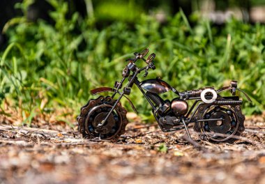 Ev yapımı metal model. Oyuncak spor yol bisikleti soyut yeşil arka planda yolda duruyor.