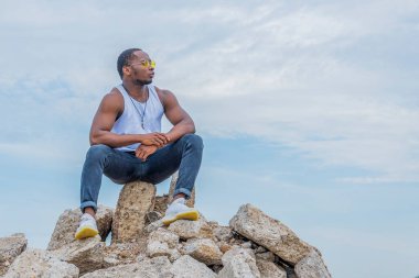 Genç ve güçlü bir adam bir dağın tepesine oturmuş ıslık çalıp gökyüzüne bakıyordu.