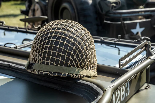 绿色军事头盔与网在车 — 图库照片
