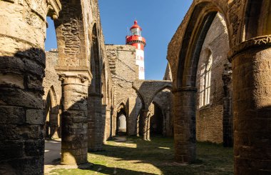 The Saint-Mathieu lighthouse behind the ruins of the abbey Saint-Mathieu de Fine-Terre in Plougonvelin (Finistere, France) clipart