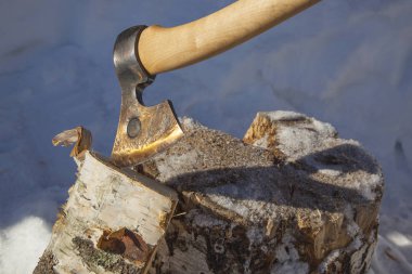 Kış günü odun ve kütük kesmek için bir balta.