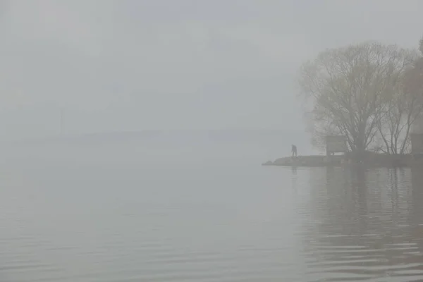 fog over water and fisherman in the fog on volga river