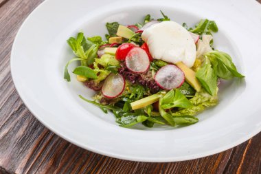 Beyaz tabakta saban süren yumurta salatası.