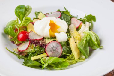 Beyaz tabakta saban süren yumurta salatası.