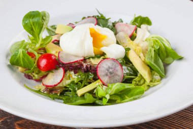 Beyaz tabakta saban süren yumurta salatası.