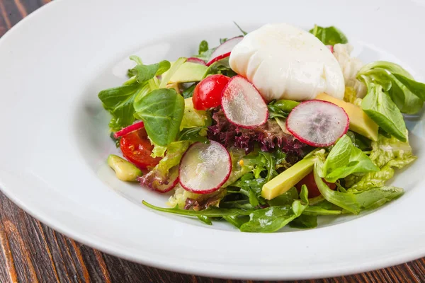 Beyaz tabakta saban süren yumurta salatası.