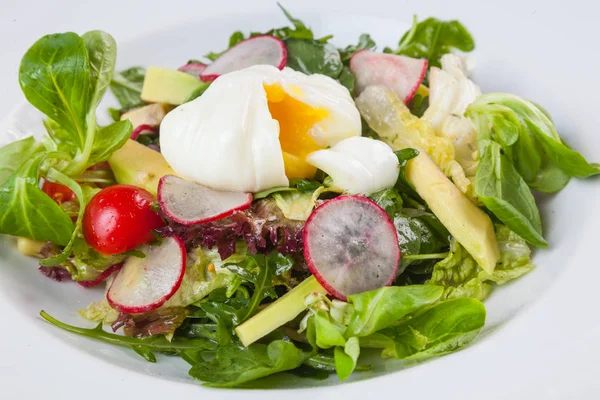 Beyaz tabakta saban süren yumurta salatası.