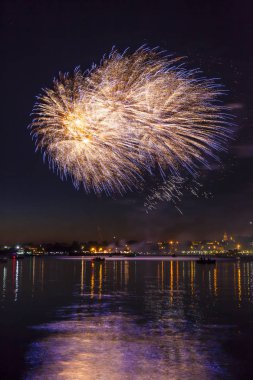 Nehri şehrin zemin karşı gece gökyüzünde havai fişek