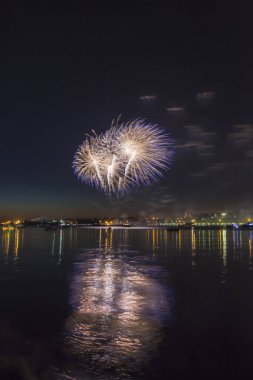 Nehri şehrin zemin karşı gece gökyüzünde havai fişek