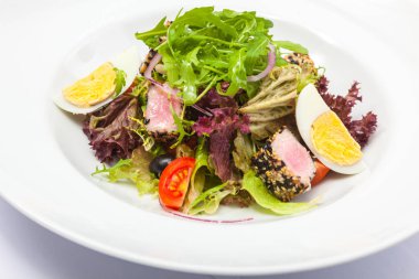Ton balıklı salata ve beyaz tabakta yumurta.