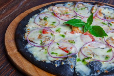 Siyah hamurlu pizza ve hindi.