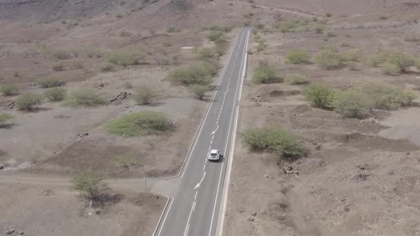 カーボベルデのサンティアゴ島のシダーデ ヴェルハ近くの砂漠の道路で運転する車の未グレードの航空写真 — ストック動画