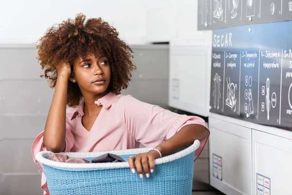 Fiatal fekete afrikai-amerikai nő, tárolás egy kosár ruhák-t — Stock Fotó