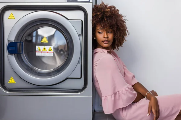 Junge schwarzafrikanisch-amerikanische Frau wartet darauf, dass ihre Kleider — Stockfoto