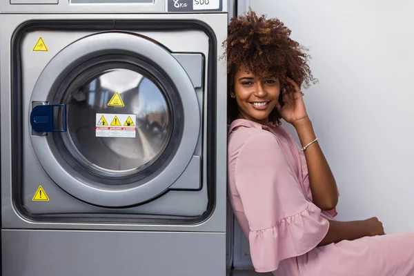 Jonge zwarte Afrikaanse Amerikaanse vrouw te wachten haar kleren als was — Stockfoto