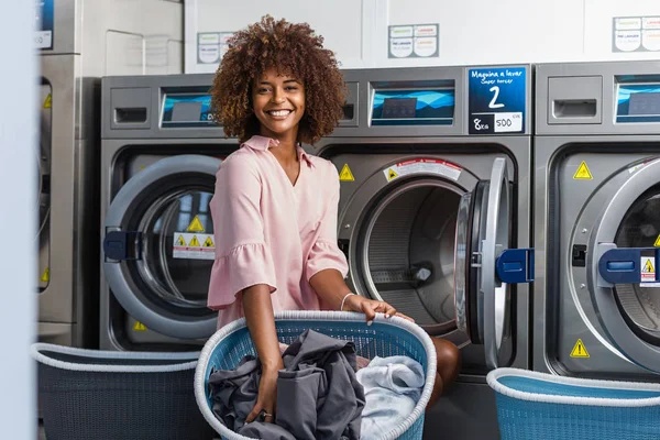 Jonge zwarte Afrikaanse Amerikaanse vrouw haar kleren wassen in een auto — Stockfoto