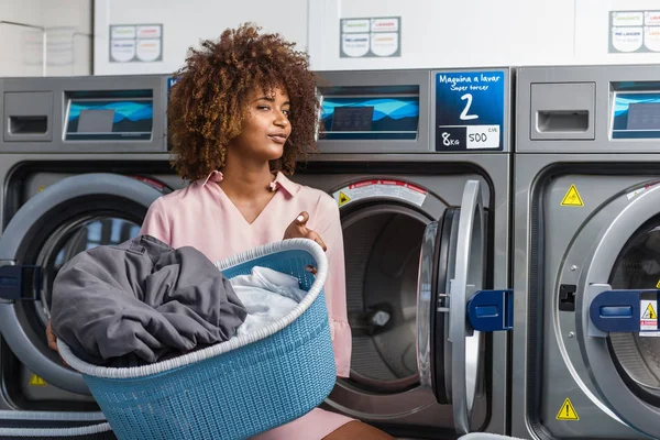 Jonge zwarte Afrikaanse Amerikaanse vrouw haar kleren wassen in een auto — Stockfoto