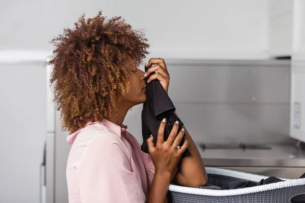 Jonge zwarte Afrikaanse Amerikaanse vrouw haar kleren wassen in een auto — Stockfoto