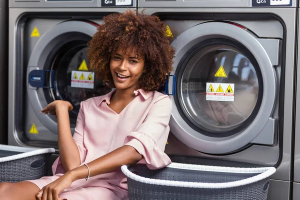 Jonge zwarte Afrikaanse Amerikaanse vrouw te wachten haar kleren als was — Stockfoto