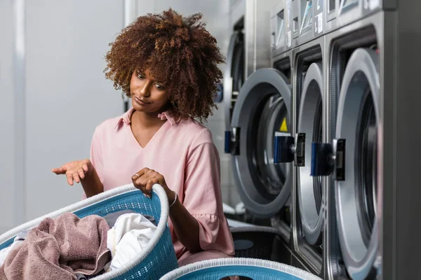 Fiatal fekete afrikai-amerikai nő, tárolás egy kosár ruhák-t — Stock Fotó