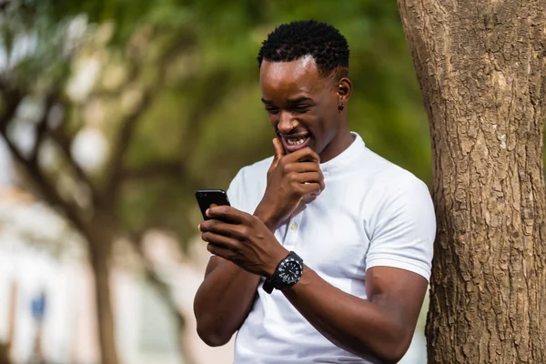 Retrato al aire libre de un joven negro afroamericano mensajes de texto —  Fotos de Stock