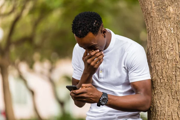 Außenporträt eines jungen schwarzafrikanisch-amerikanischen Mannes beim SMS-Schreiben — Stockfoto