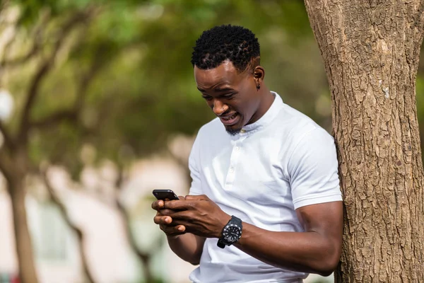 Außenporträt eines jungen schwarzafrikanisch-amerikanischen Mannes beim SMS-Schreiben — Stockfoto