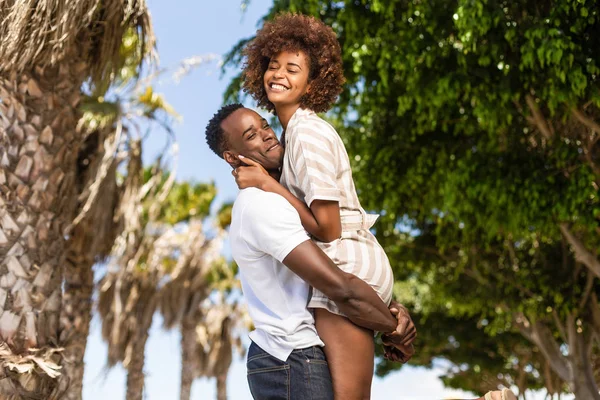 Outdoor protrait of black african american couple - Guy carrying — Stock Photo, Image