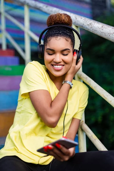 Jolie jeune femme noire afro-américaine écoutant de la musique avec intelligence — Photo